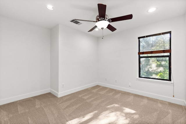 empty room featuring light carpet, baseboards, and visible vents