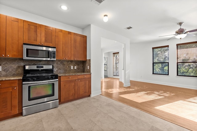 kitchen with tasteful backsplash, visible vents, appliances with stainless steel finishes, and brown cabinets