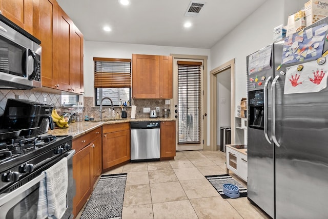 kitchen featuring light tile patterned floors, visible vents, decorative backsplash, appliances with stainless steel finishes, and a sink