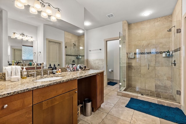 full bathroom featuring a stall shower, vanity, visible vents, and tile patterned floors