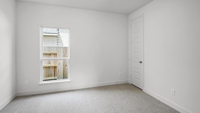 carpeted spare room featuring baseboards