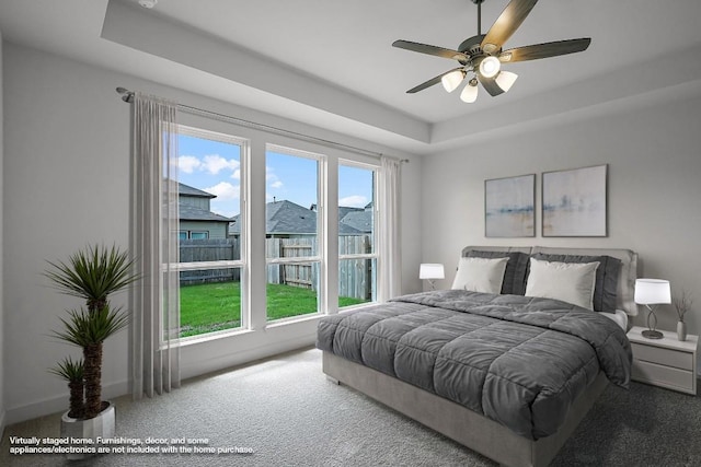 bedroom featuring a ceiling fan, carpet, a raised ceiling, and baseboards