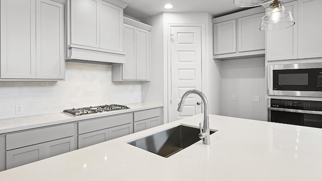 kitchen with built in microwave, stainless steel oven, and light countertops