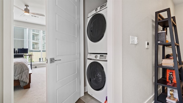 clothes washing area with carpet flooring, stacked washer / dryer, and ceiling fan