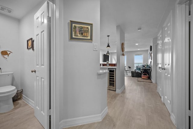 hallway featuring wine cooler and light hardwood / wood-style floors