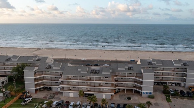 birds eye view of property with a water view and a beach view