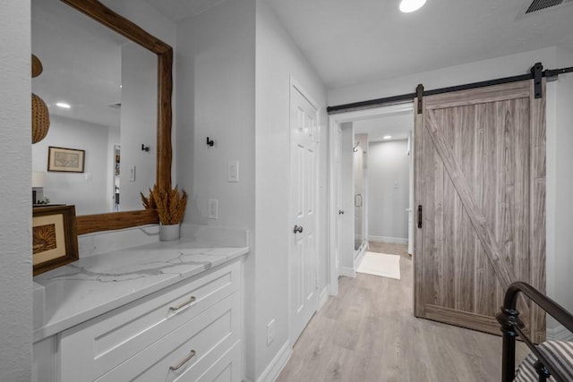 hall featuring a barn door and light wood-type flooring