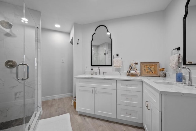 bathroom with hardwood / wood-style flooring, vanity, and a shower with shower door