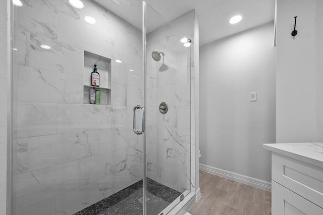 bathroom with hardwood / wood-style flooring, vanity, and an enclosed shower