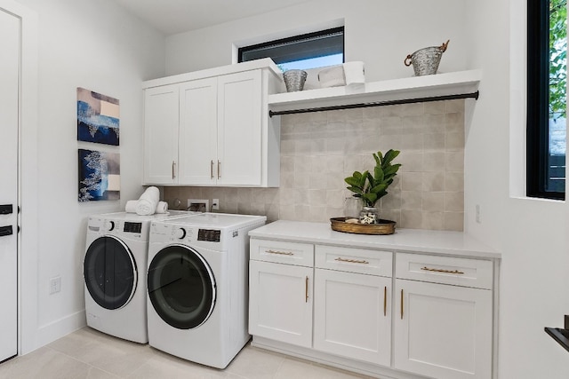 laundry area with washer and dryer, light tile patterned floors, and cabinets