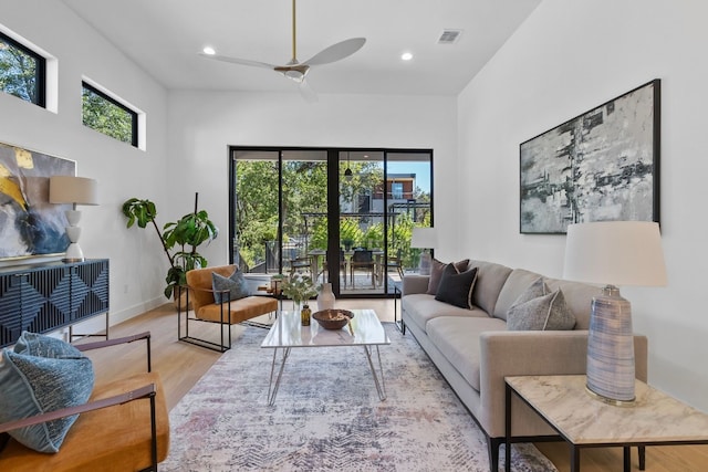 living room with light wood-type flooring and ceiling fan