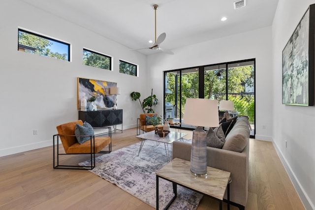 living room with ceiling fan, light hardwood / wood-style floors, and a healthy amount of sunlight