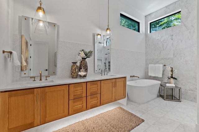 bathroom with vanity, tile walls, and a bathtub