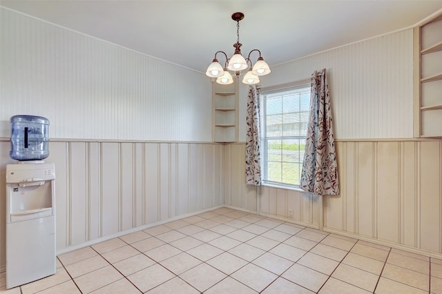 spare room featuring an inviting chandelier and light tile flooring