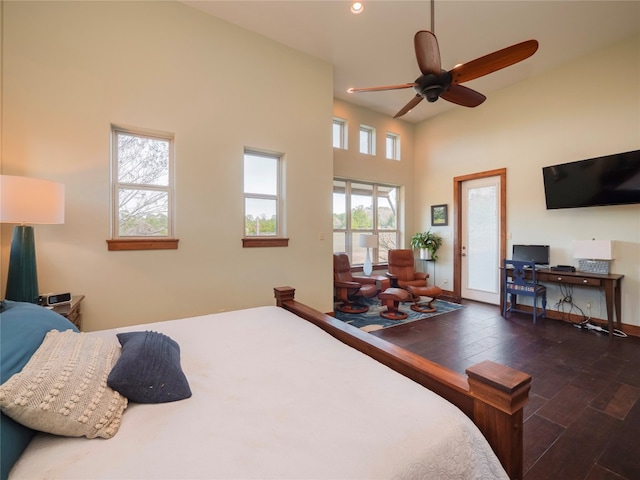 bedroom with a high ceiling, ceiling fan, and dark wood-type flooring