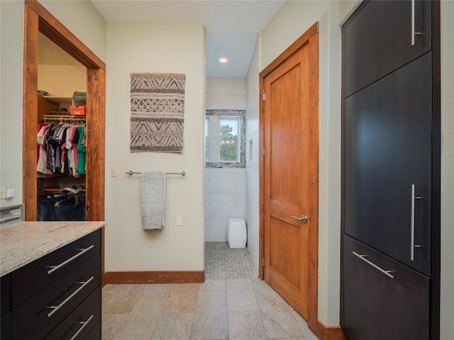 bathroom featuring tile flooring, tile walls, and vanity