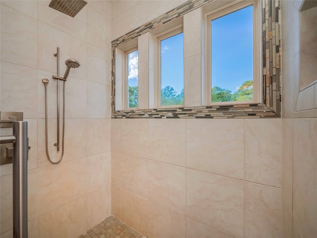 bathroom with tiled shower and a wealth of natural light