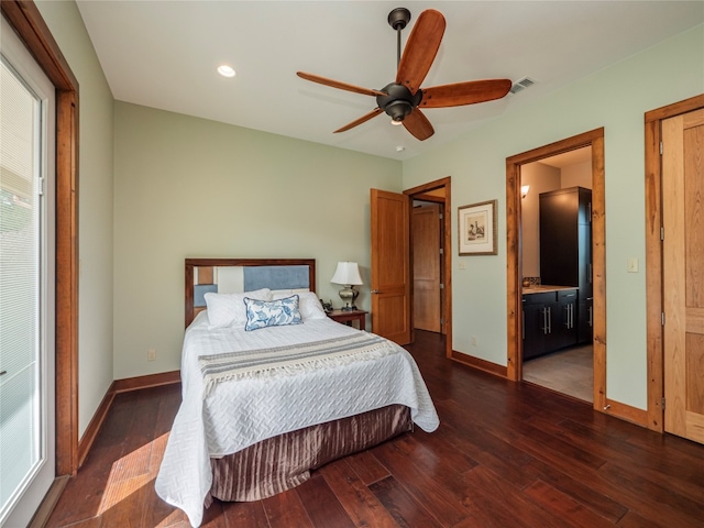 bedroom with ceiling fan, ensuite bath, and dark wood-type flooring