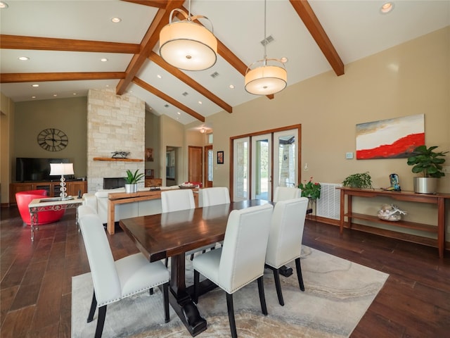 dining area featuring beamed ceiling, high vaulted ceiling, french doors, dark hardwood / wood-style floors, and a fireplace