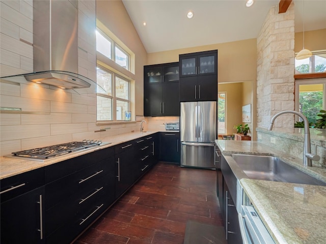 kitchen with backsplash, wall chimney range hood, appliances with stainless steel finishes, and light stone counters