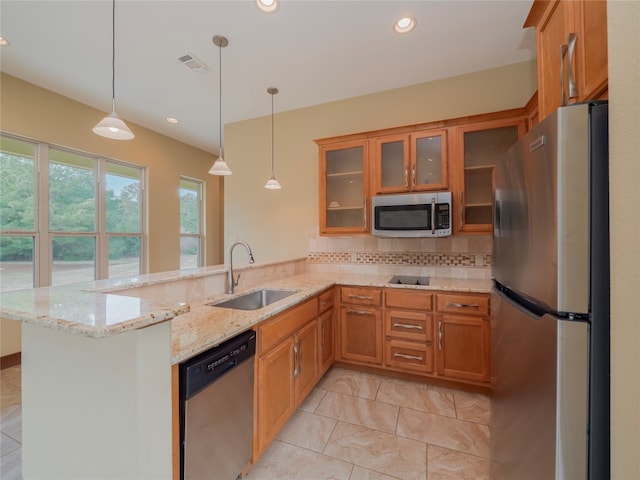 kitchen featuring kitchen peninsula, decorative light fixtures, sink, and stainless steel appliances