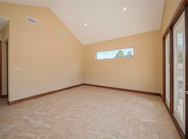 empty room featuring high vaulted ceiling and light tile floors