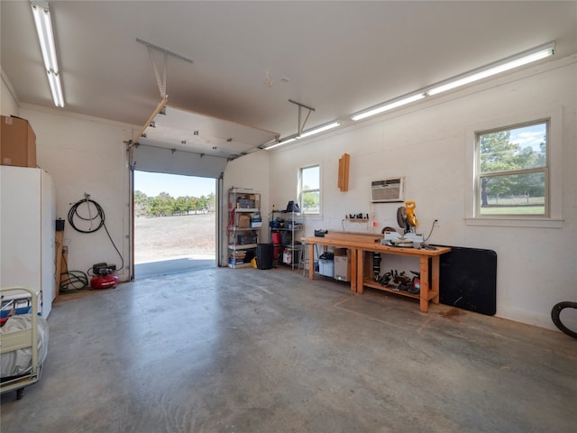 garage featuring a workshop area and a wall mounted AC