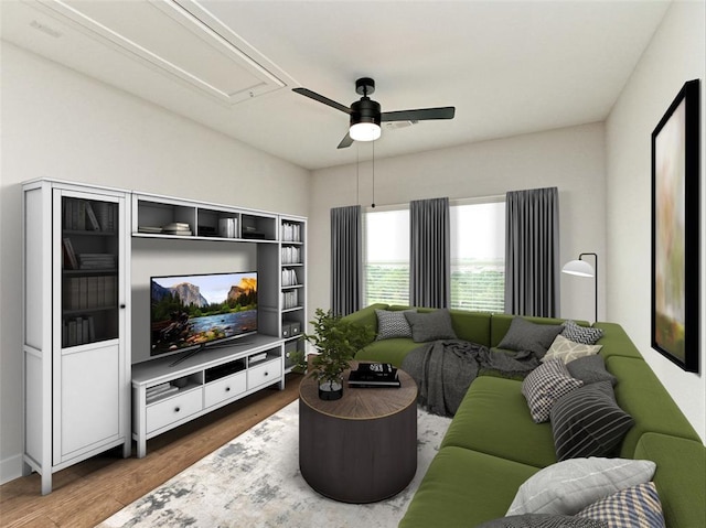 living room with a ceiling fan, attic access, and wood finished floors