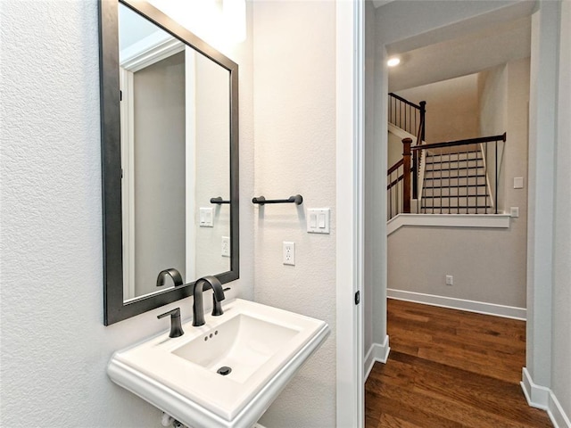 bathroom featuring a sink, baseboards, and wood finished floors