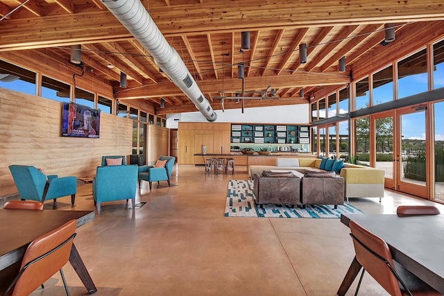 living area with a towering ceiling and finished concrete floors