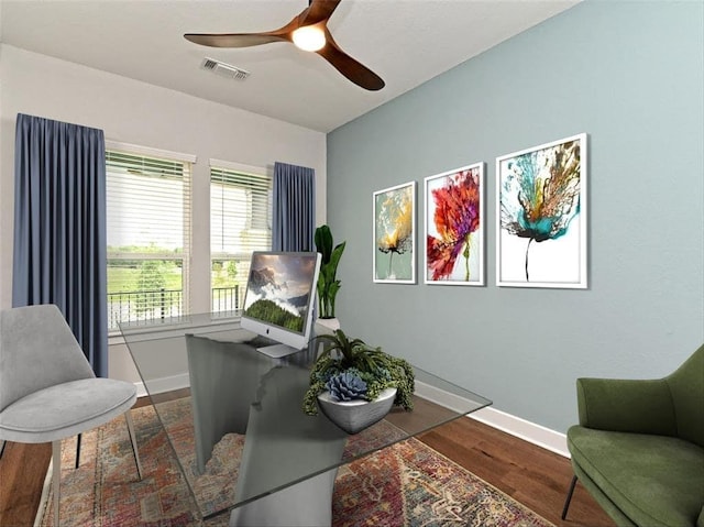 living area featuring visible vents, ceiling fan, baseboards, and wood finished floors