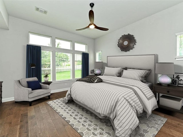 bedroom with visible vents, multiple windows, and wood finished floors