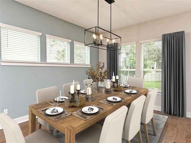 dining area featuring a chandelier, baseboards, and wood finished floors