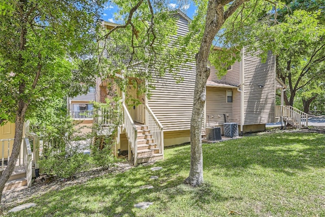 exterior space with a lawn and central AC unit