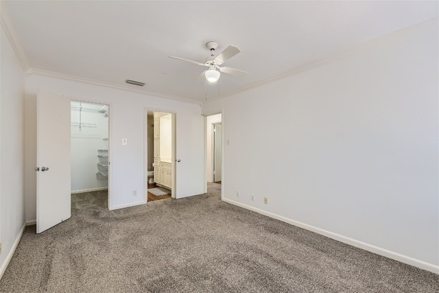 unfurnished bedroom with ensuite bath, ceiling fan, and carpet flooring