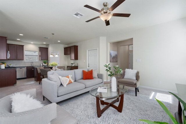 living room featuring sink, ceiling fan, and light tile flooring