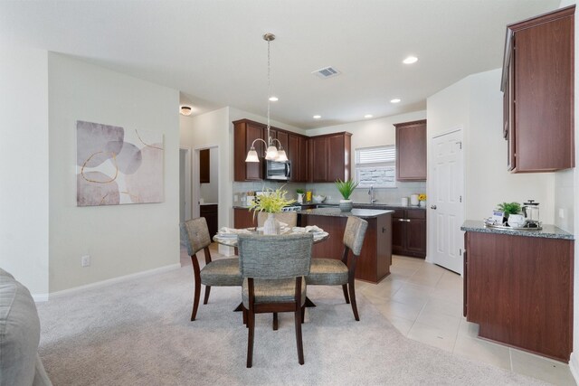 carpeted dining area with sink and an inviting chandelier