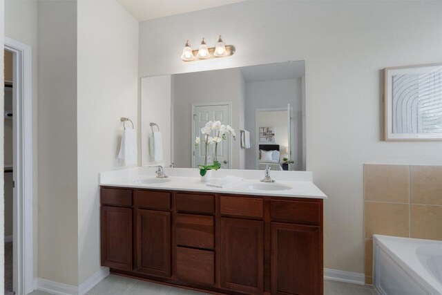 bathroom featuring a bath to relax in, double sink vanity, and tile flooring