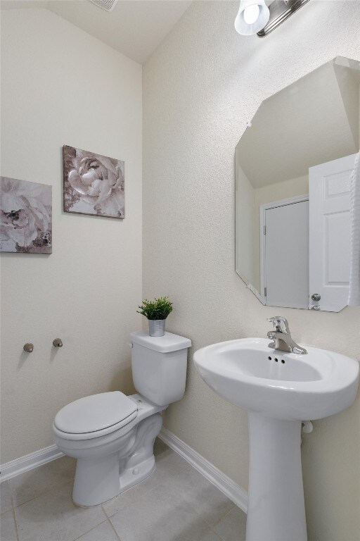 bathroom with tile flooring and toilet