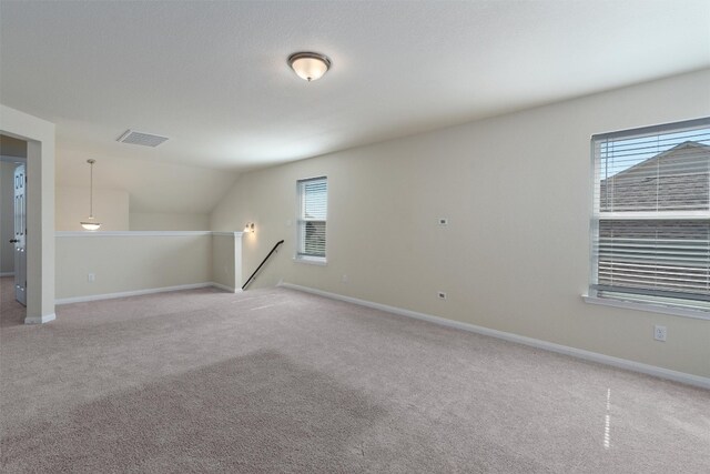 empty room with light colored carpet and vaulted ceiling