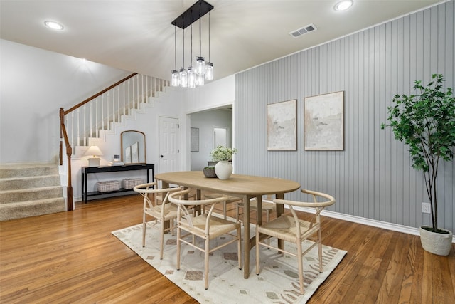 dining space with wood-type flooring and a chandelier