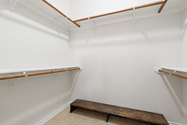 walk in closet with light tile patterned floors