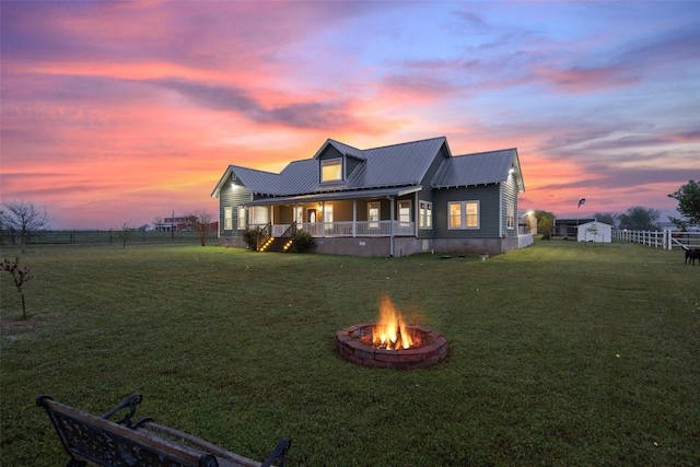 back house at dusk with a lawn and a fire pit