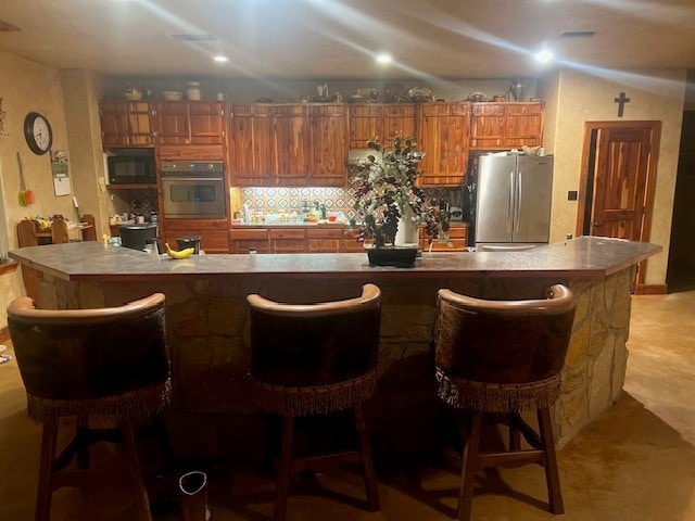 kitchen featuring a kitchen breakfast bar, stainless steel fridge, and a spacious island