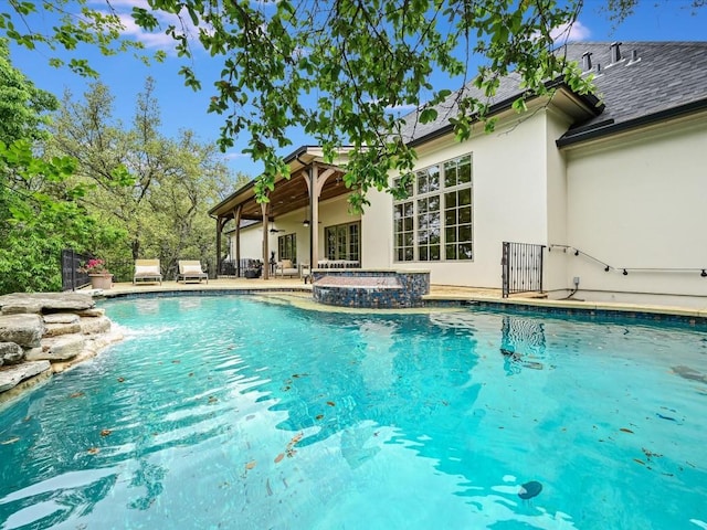 view of pool featuring a patio area, an in ground hot tub, and ceiling fan