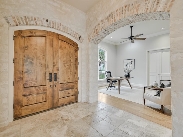 tiled entryway with ornamental molding and ceiling fan