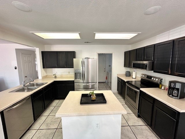 kitchen featuring a center island, sink, light tile floors, and stainless steel appliances