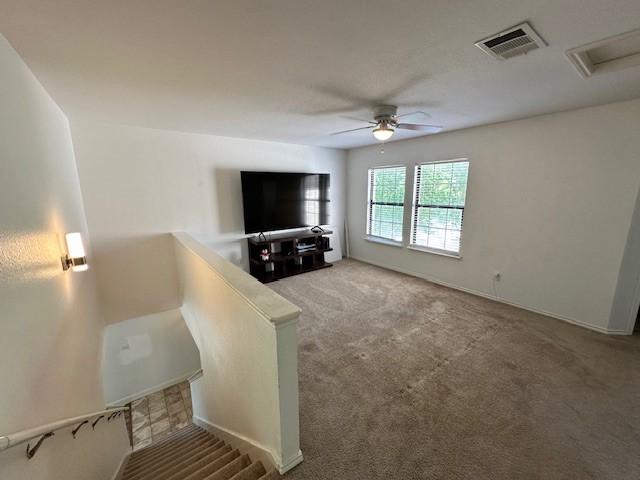 carpeted living room with ceiling fan