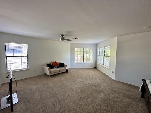 interior space featuring a textured ceiling, ceiling fan, and carpet floors