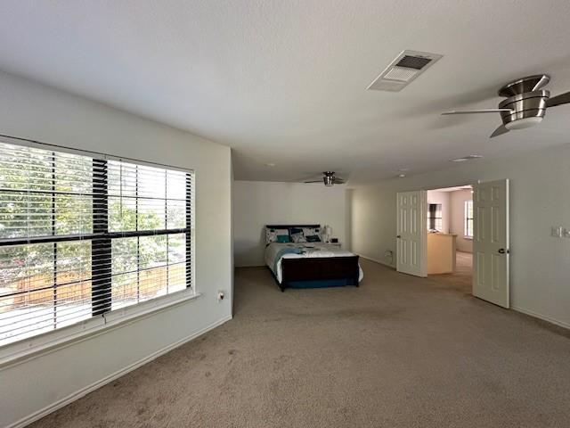 interior space featuring a textured ceiling, carpet, and ceiling fan